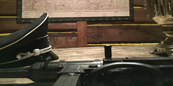Officer's cap and rifle on a map table